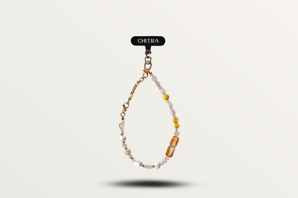 Golden Winter hanging from a phone as a charm