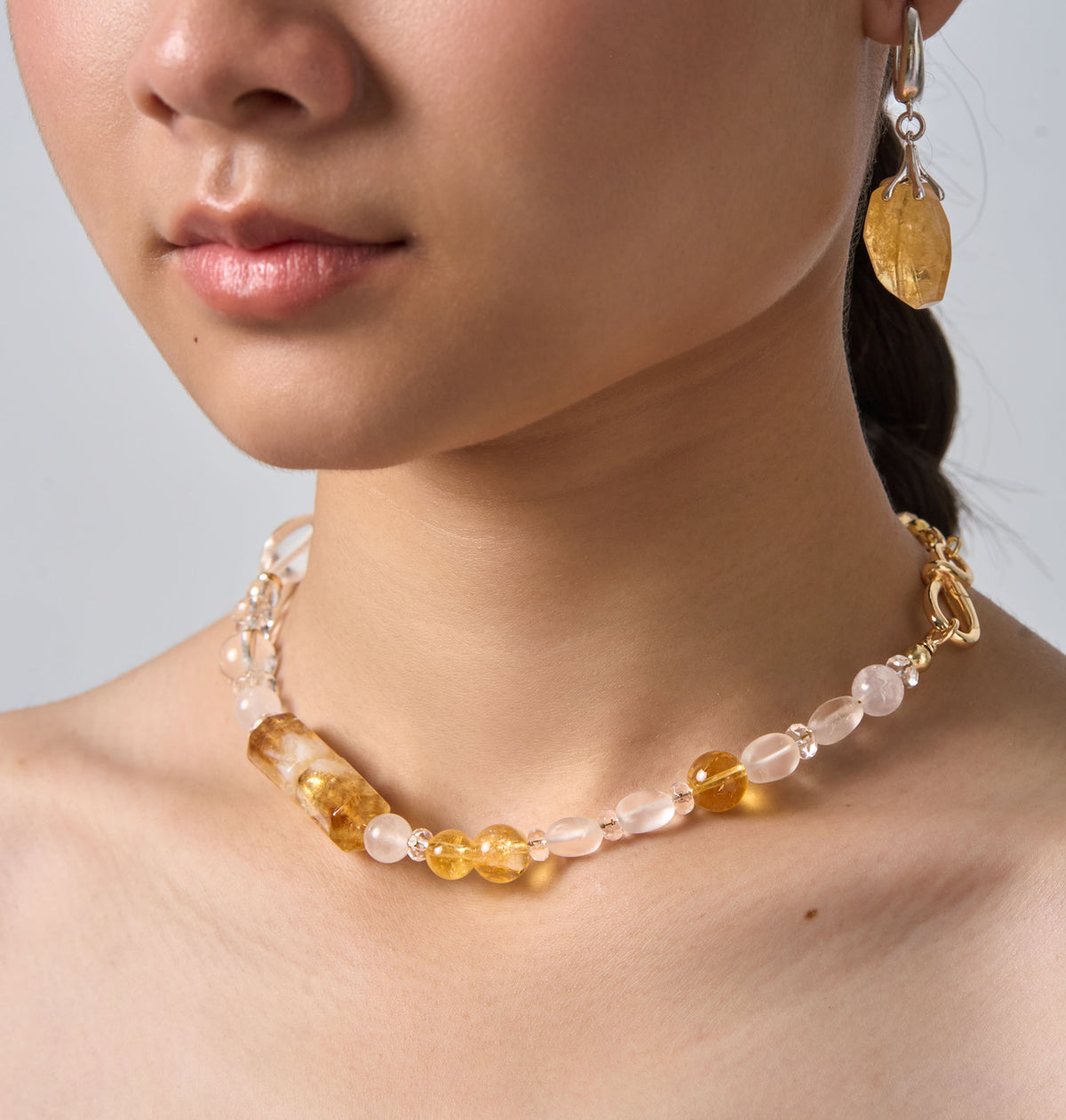 The Golden Winter worn as a necklace at the neck, with matching drop earrings