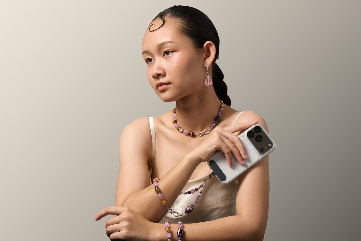 The Violet Chocolate worn full length, necklace and bracelet with the charm on a phone