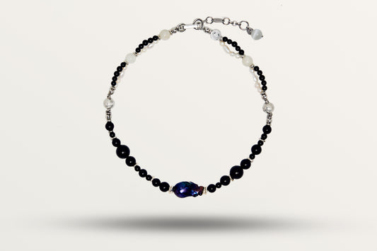 The Black Pearl as a necklace, one closed loop of black stones and white pearls with a dark baroque pearl