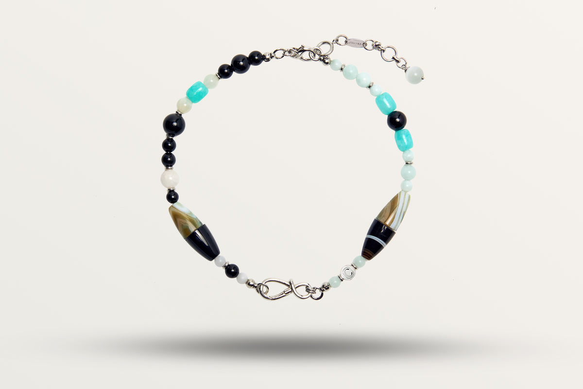 The Serenity as a necklace, one closed loop of black and turquoise stones with two striped barrel beads