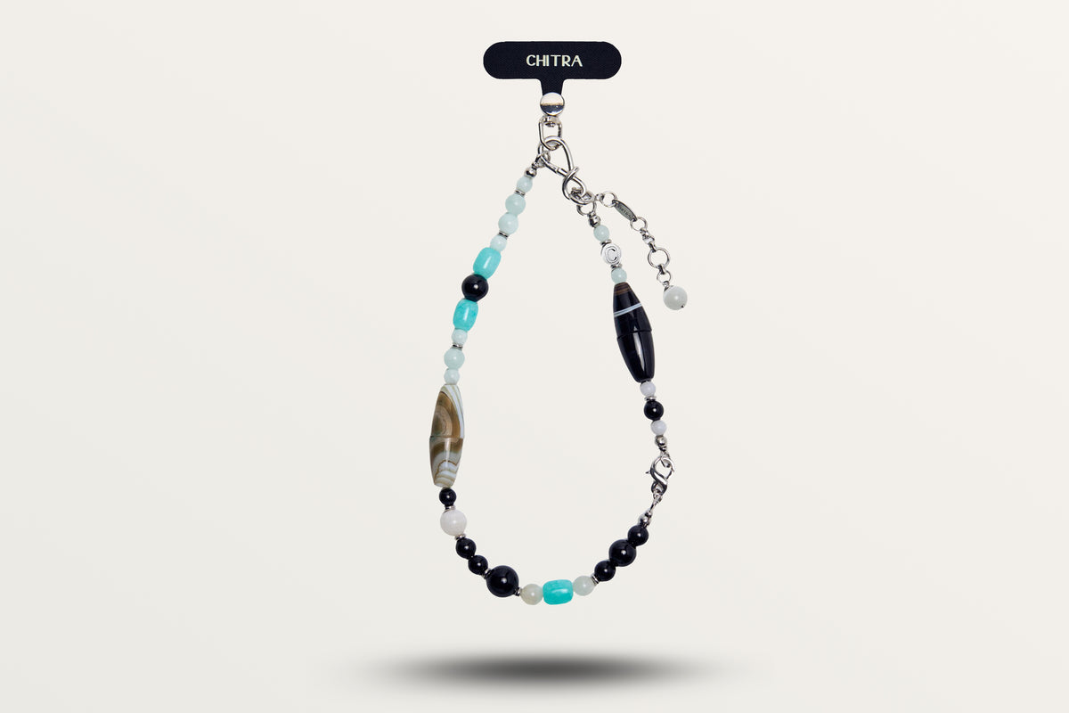 The Serenity hanging as a phone charm, black and turquoise stones with striped barrel beads