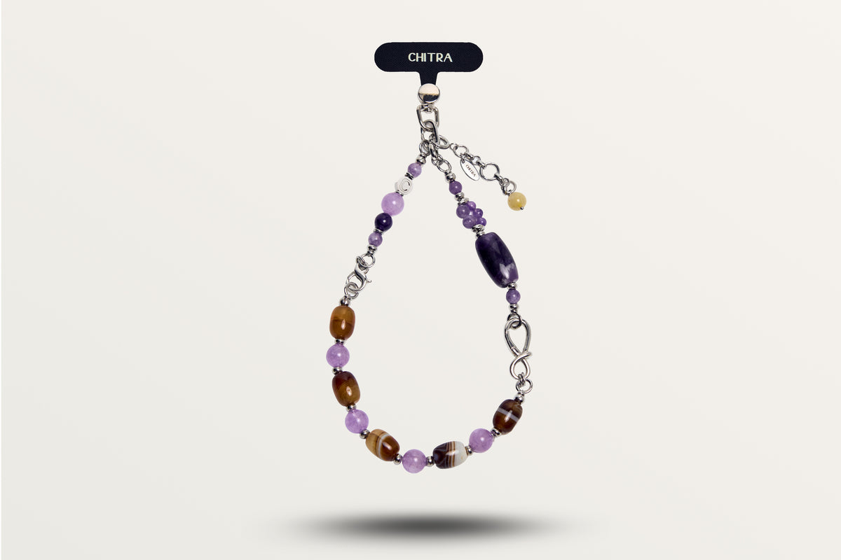 The Violet Chocolate hanging as a phone charm, purple and brown banded stones